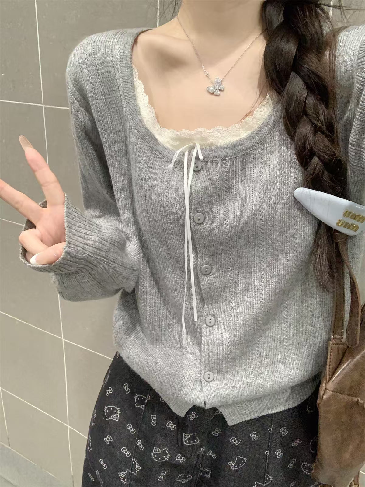 Grey knit cardigan - model wearing with printed pants