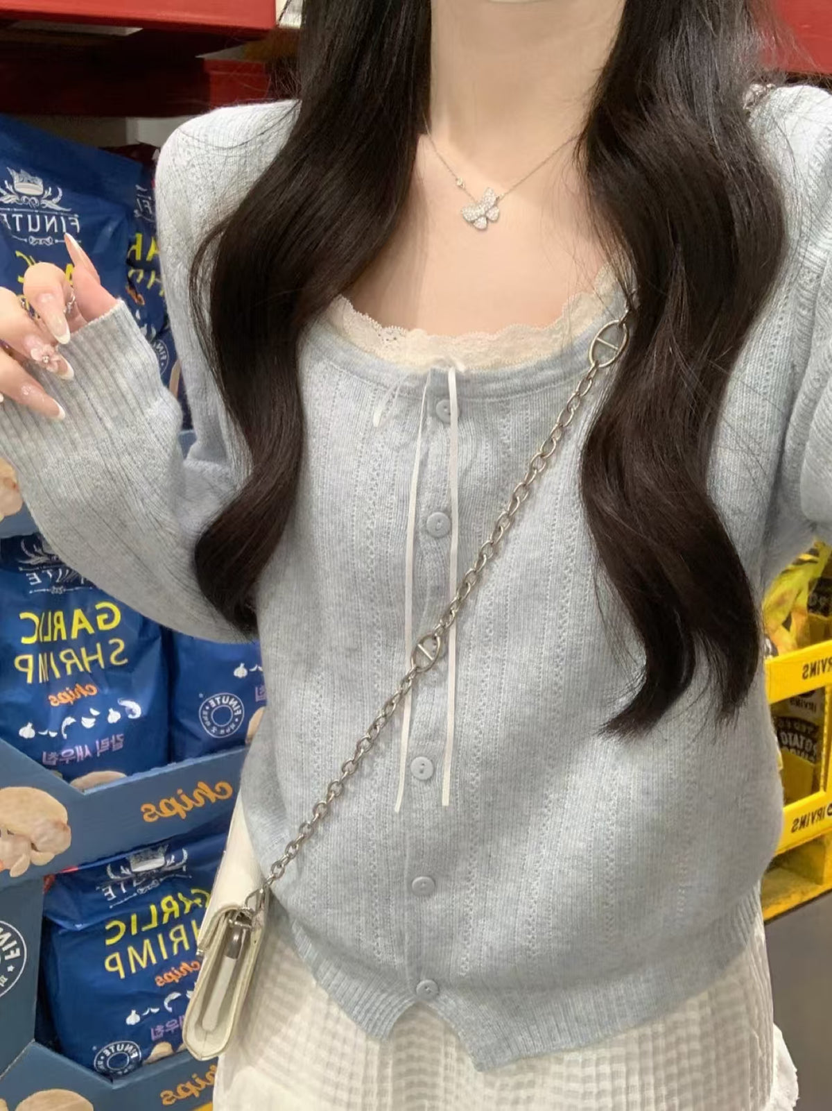 Blue knit cardigan front view - model wearing at store